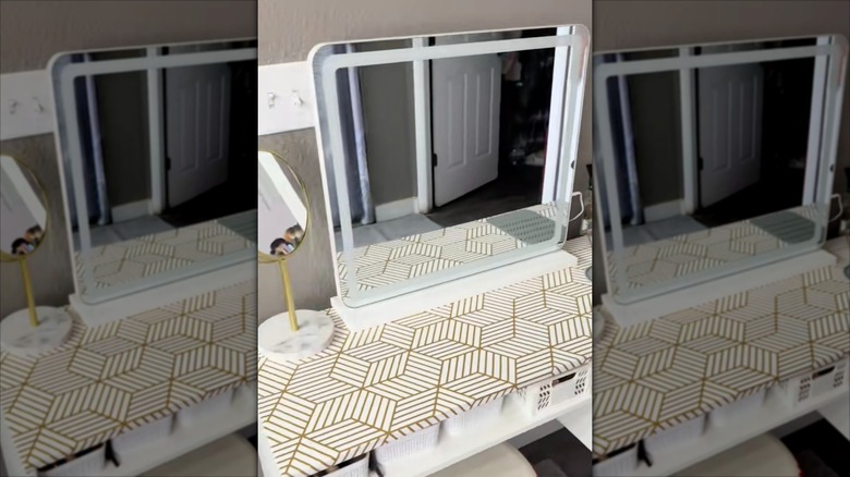 A bathroom vanity covered in adhesive shelf liner with decorative pattern.