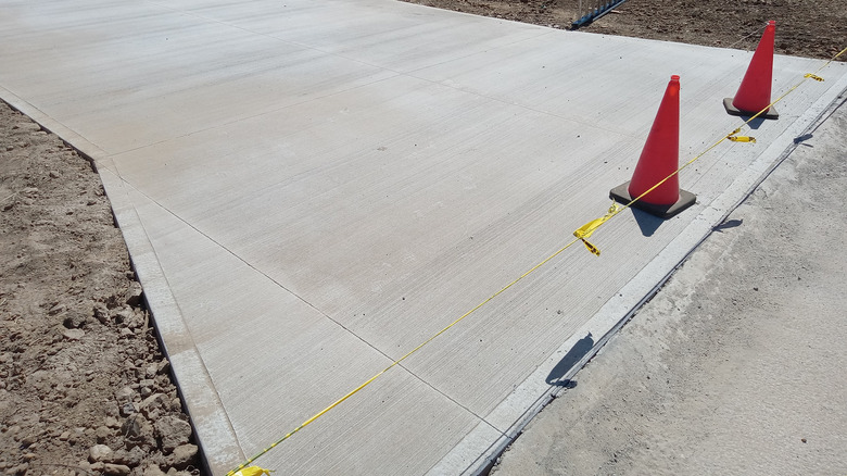 Solid poured concrete driveway curing in the sun