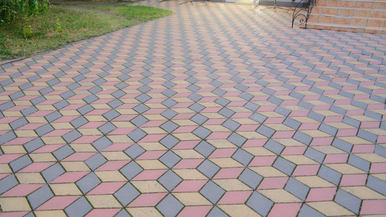 Multi-colored blocks make up a driveway leading to a house