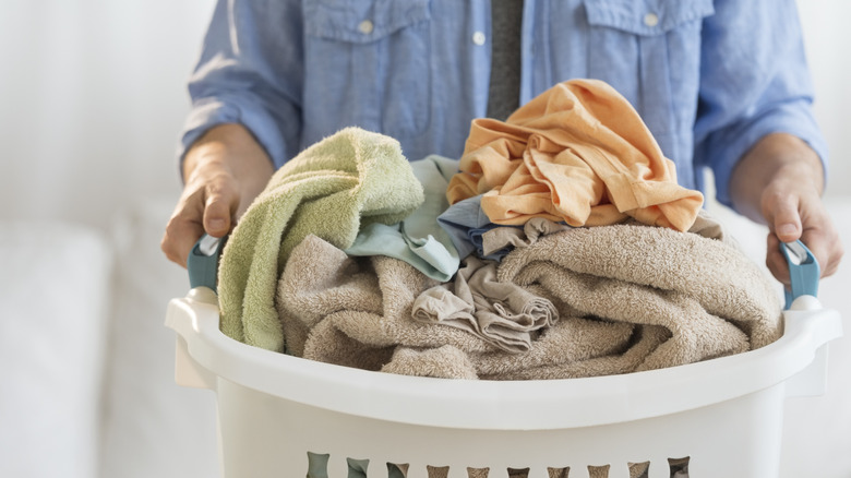 Hands holding large basket of laundry