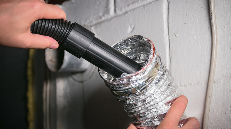 Close-up of a person vacuum cleaning dryer ducts