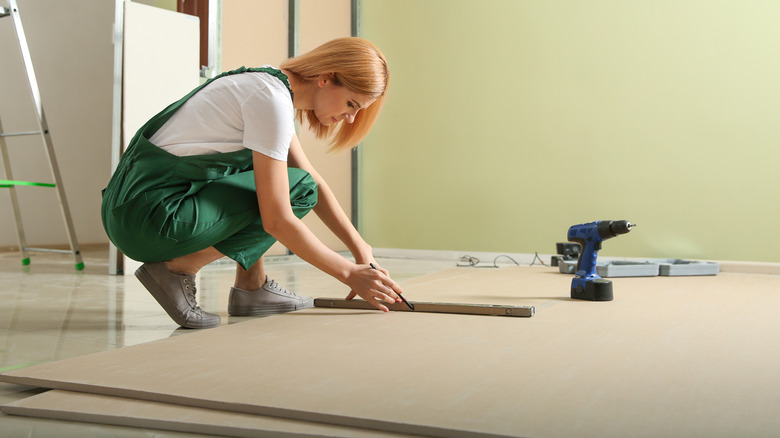 woman doing home drywall work 