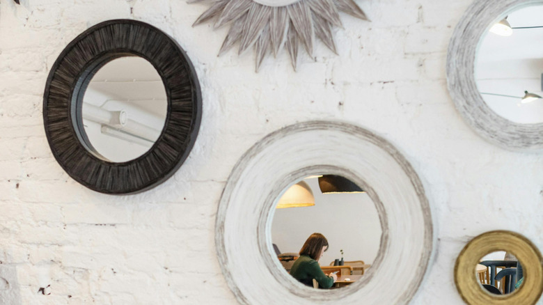 Assorted mirrors arranged on an accent wall