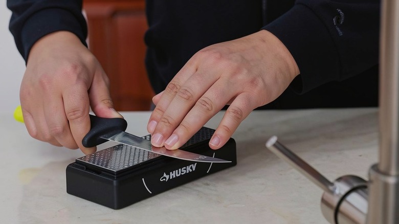 A person using Husky block sharpener