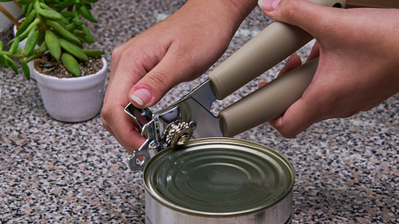 Person using a can opener