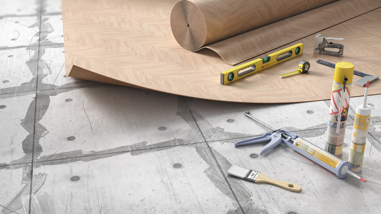 Imitation wood linoleum floor and tools over prepped subfloor