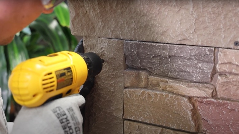 man attaching brick veneer