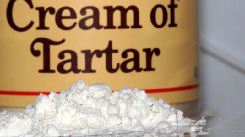 A pile of cream of tartar on a counter with a tub behind it