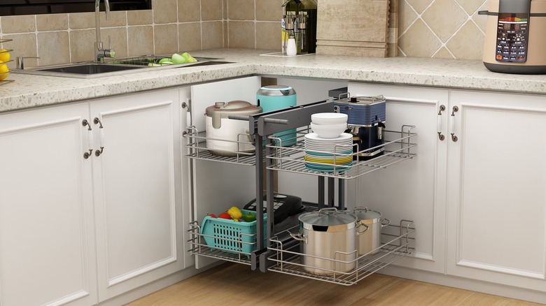 blind corner pull-out kitchen organizer with small appliances, dishes, and pots