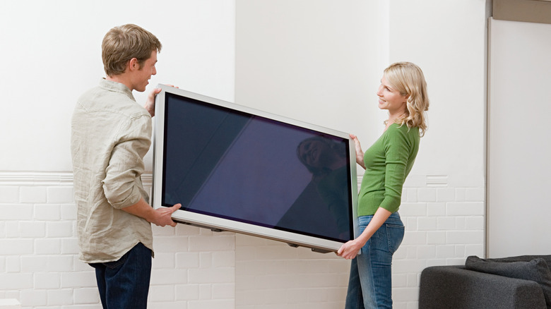 A couple installing a new TV