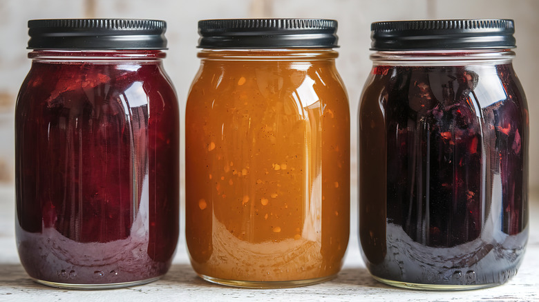 mason jars with metal lids containing various jams