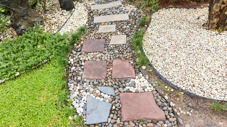 Gravel surrounding garden pavers and contained within a garden bed.