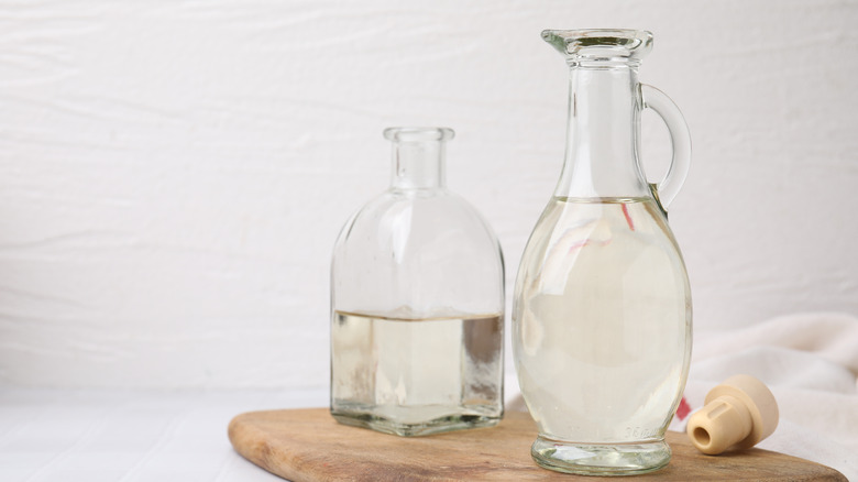 Vinegar in a glass jug and bottle placed on a table