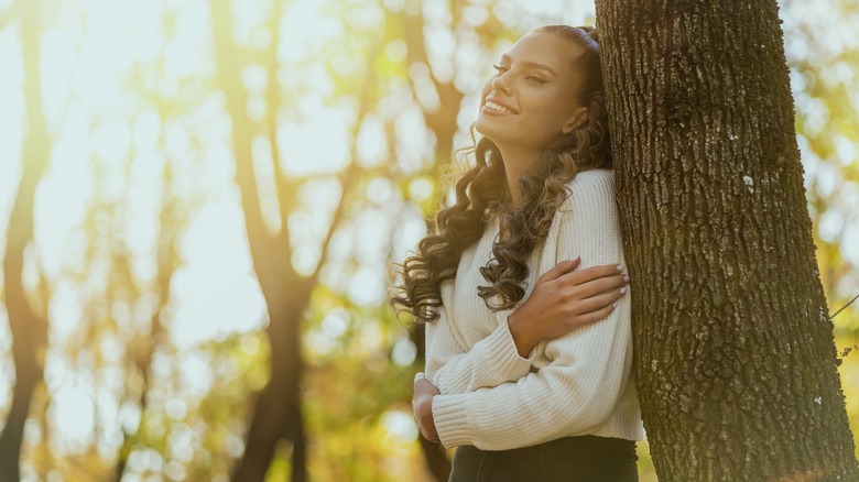 woman leaning on tree