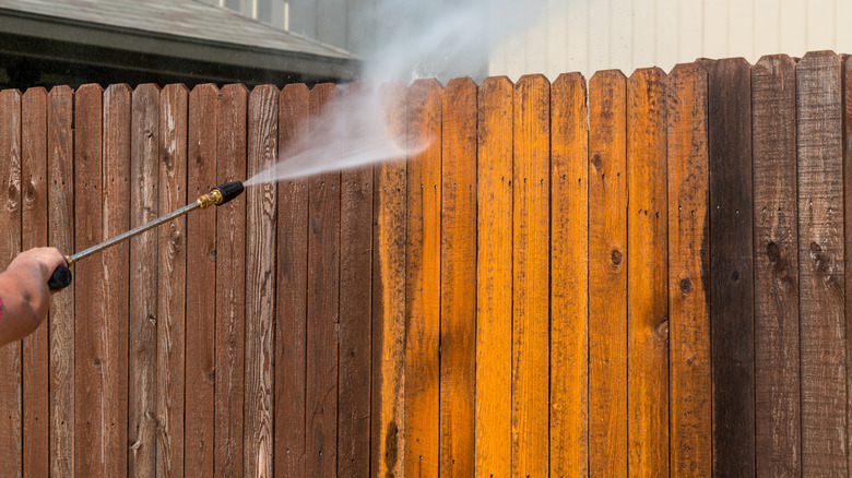 spraying a fence clean
