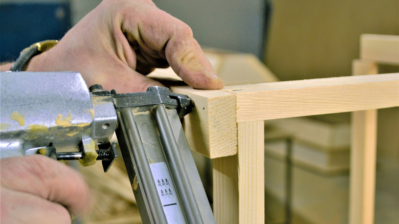 Person using a finish nailer on wood