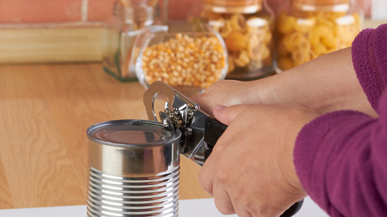 Hands using can opener
