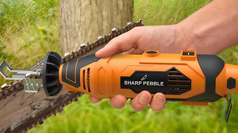 A hand holding the Sharp Pebble chainsaw sharpener
