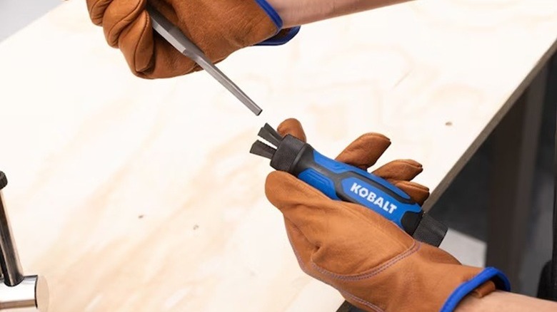 A person holding a Kobalt metal file and handle