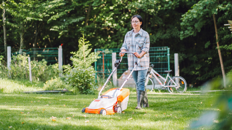 Woman mowing the grass in her lawn