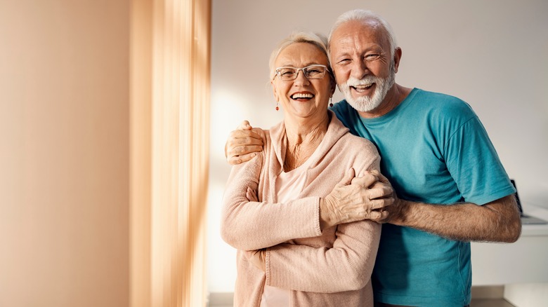Older couple smiling by window