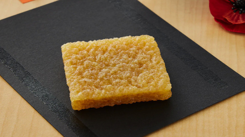 Adhesive eraser on a black paper with adhesive on the sides of it