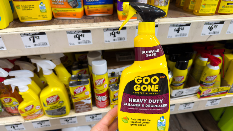 Hand holding a spray bottle of Goo Gone in a Home Depot