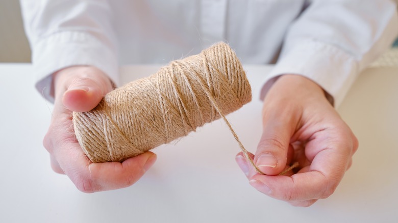 hands holding roll of twine