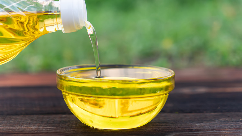 pouring cooking oil into a glass bowl