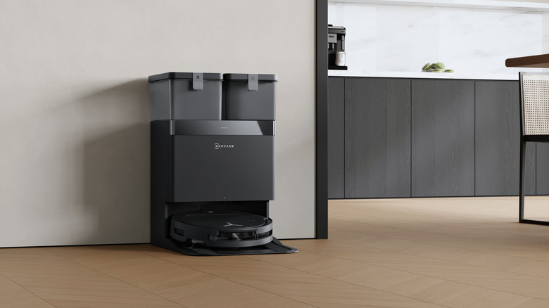 An ECOVACS floor cleaner and docking station on a wood floor