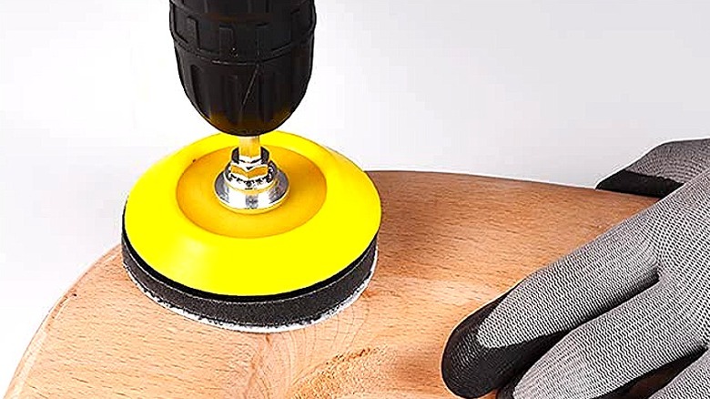 Person using sanding disc on a drill