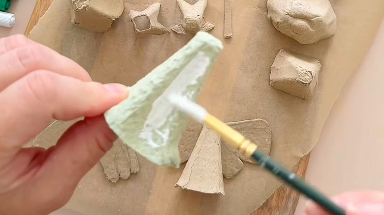 Close-up of a person painting a peak from an egg carton