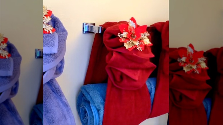 Elegantly folded towels with a decorative flower on a towel rack
