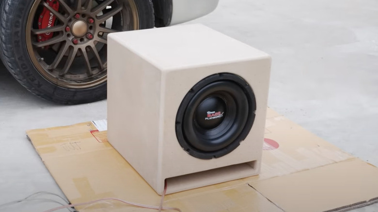 DIY subwoofer box sits outside near car