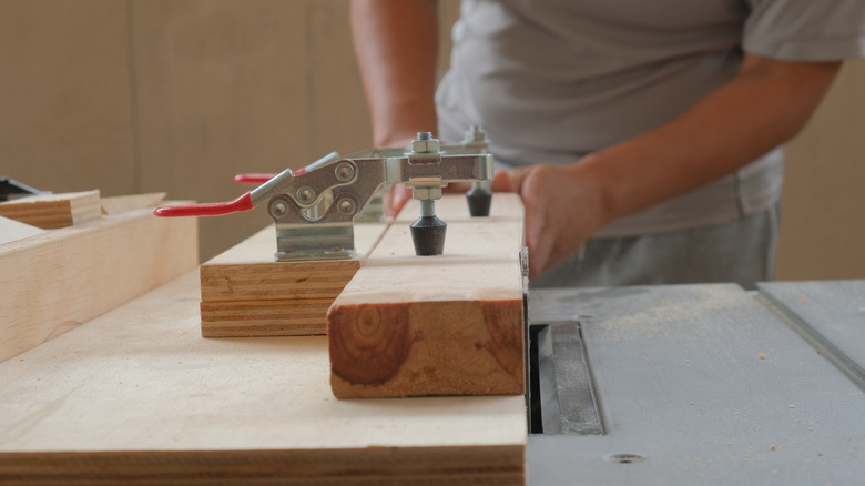person cutting wooden planks
