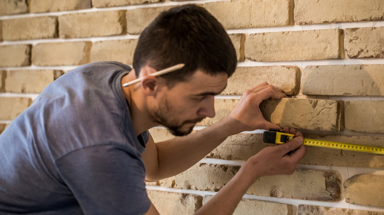 A man installing brick veneers for a feature wall