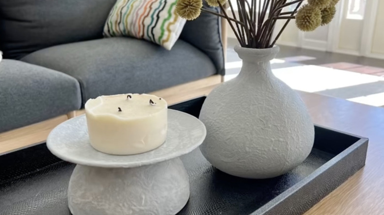 A candle holder and a vase made from Dollar Tree materials.