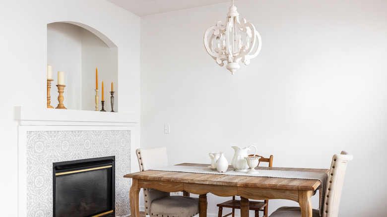 A white chandelier over a dining room table