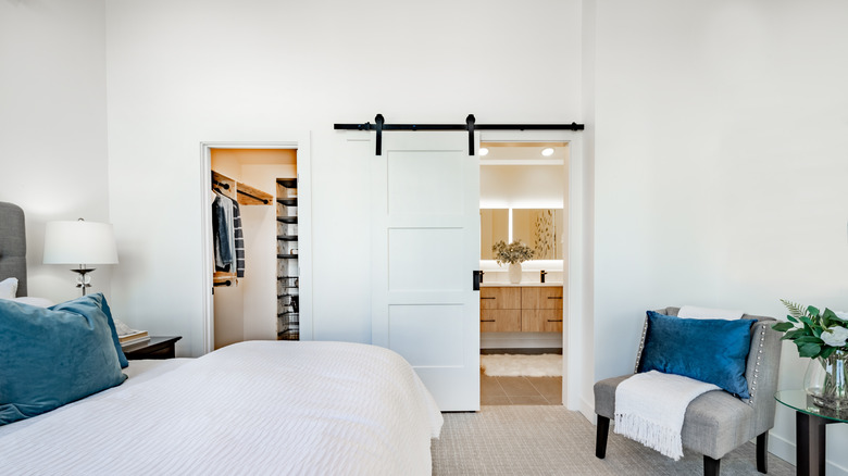 Bedroom with sliding barn doors hanging in front of the bathroom