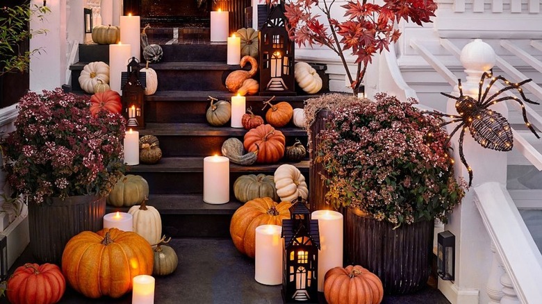 Porch steps full of pumpkins and candles