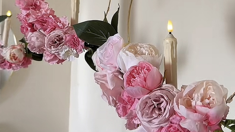 Two hanging floral centerpieces with artificial pink flowers and LED taper candles.
