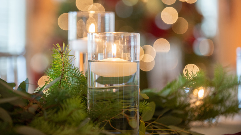 floating candle in jar of water on table