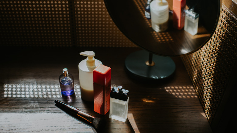 skincare and makeup items on counter in front of mirror