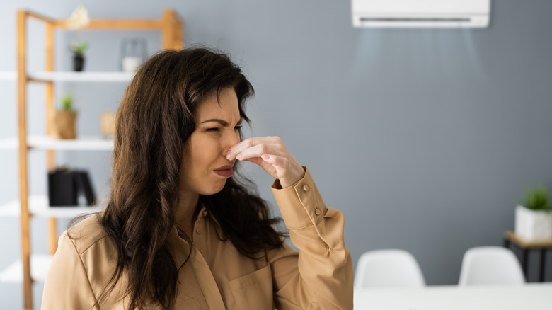 Woman smelling something foul