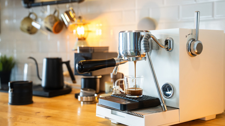 Coffee bar setup on counter in kitchen with white tile in background