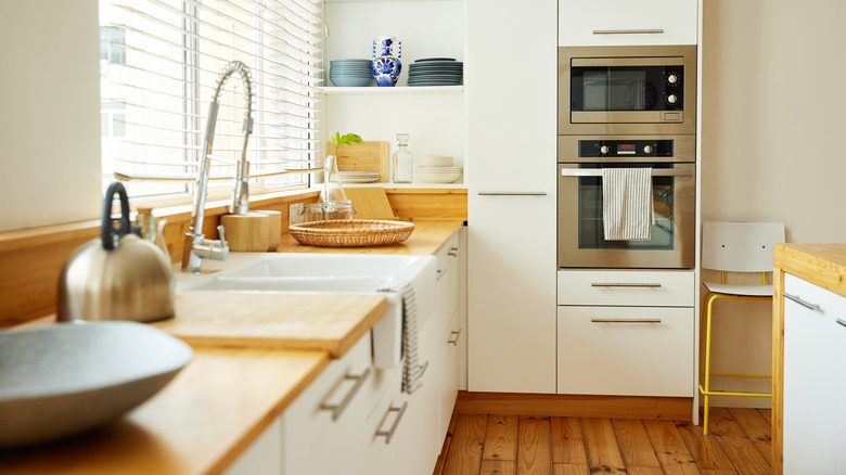 A Scandinavian style kitchen with a butcher's block countertop and flat-front cabinets
