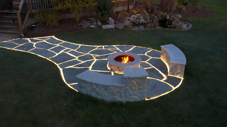 Walkway and firepit area with strip lighting running between the gaps in the stones