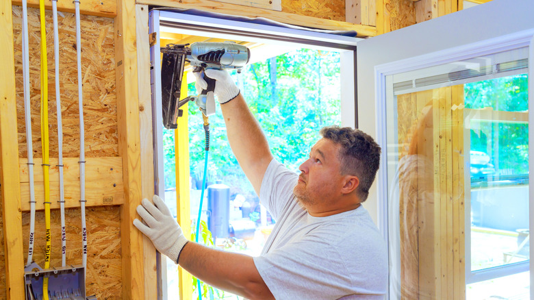 a man installs a front door in a new house