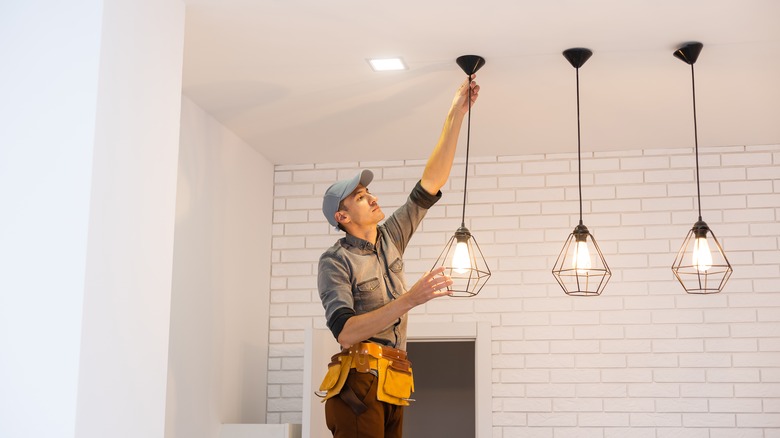 Electrician worker installation electric lamps