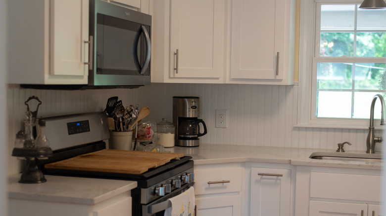 A white kitchen with a white beadboard backsplash